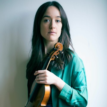 Woman long brown hair in green top holding violin