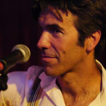 Man wearing white shirt sitting in front of mic close up