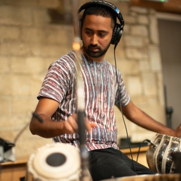 Man wearing headphones playing Sitar