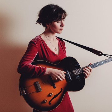 Woman in red dress playing guitar
