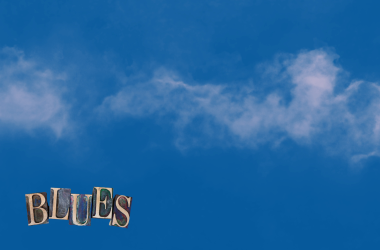 Smoke on light blue sky background. Blues text in left hand corner