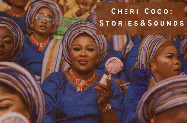 Crowd of Black women in African dress, centre woman with mini electric fan